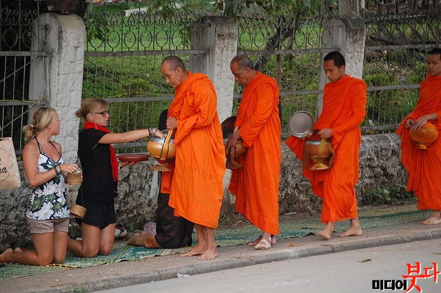 800px-Buddhist_monks_collecting_alms,_Laos.jpg